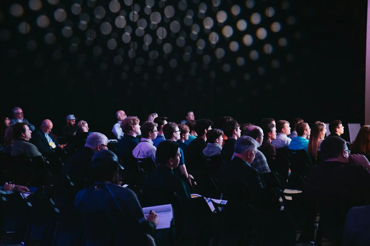 Illustrative conference audience and stage — not QSummit 2027